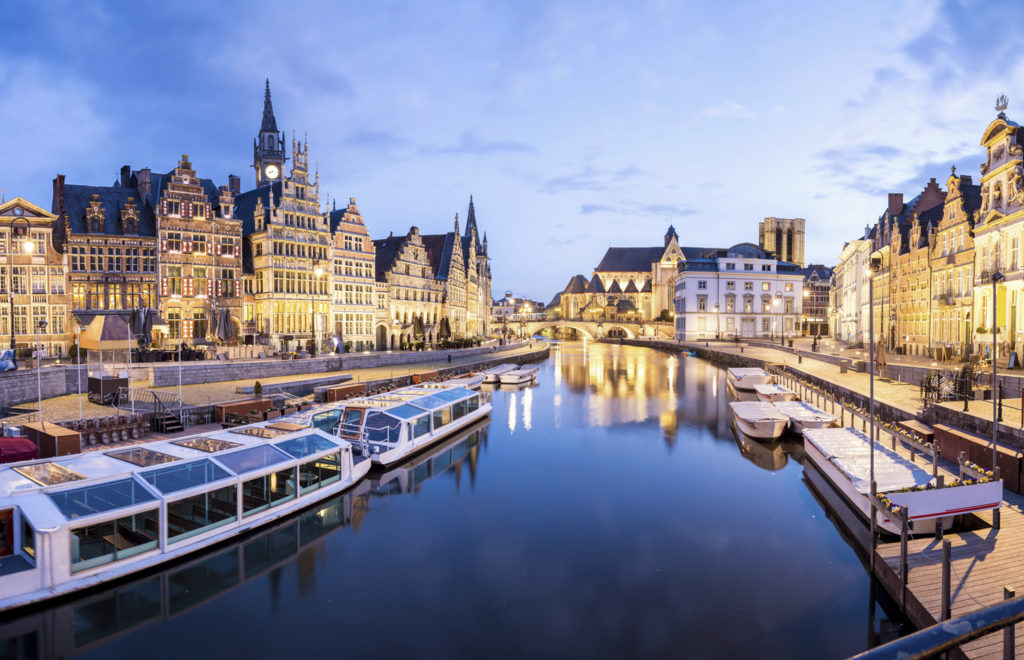 Picturesque medieval buildings on Leie river in Ghent town, Belgium at dusk.